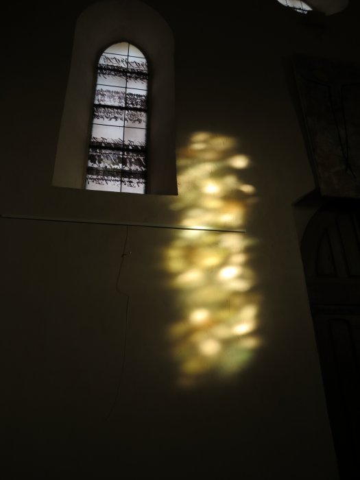 Lumière d'un vitrail sur le mur un matin